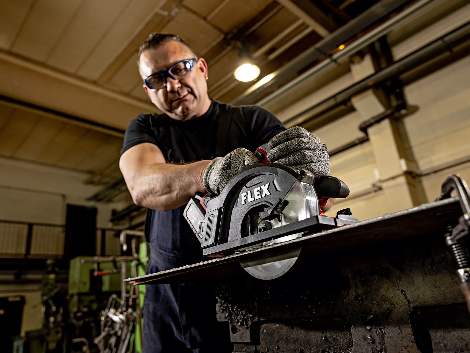 Ein Handwerker sägt Metall mit der FLEX Metall-Handkreissäge.