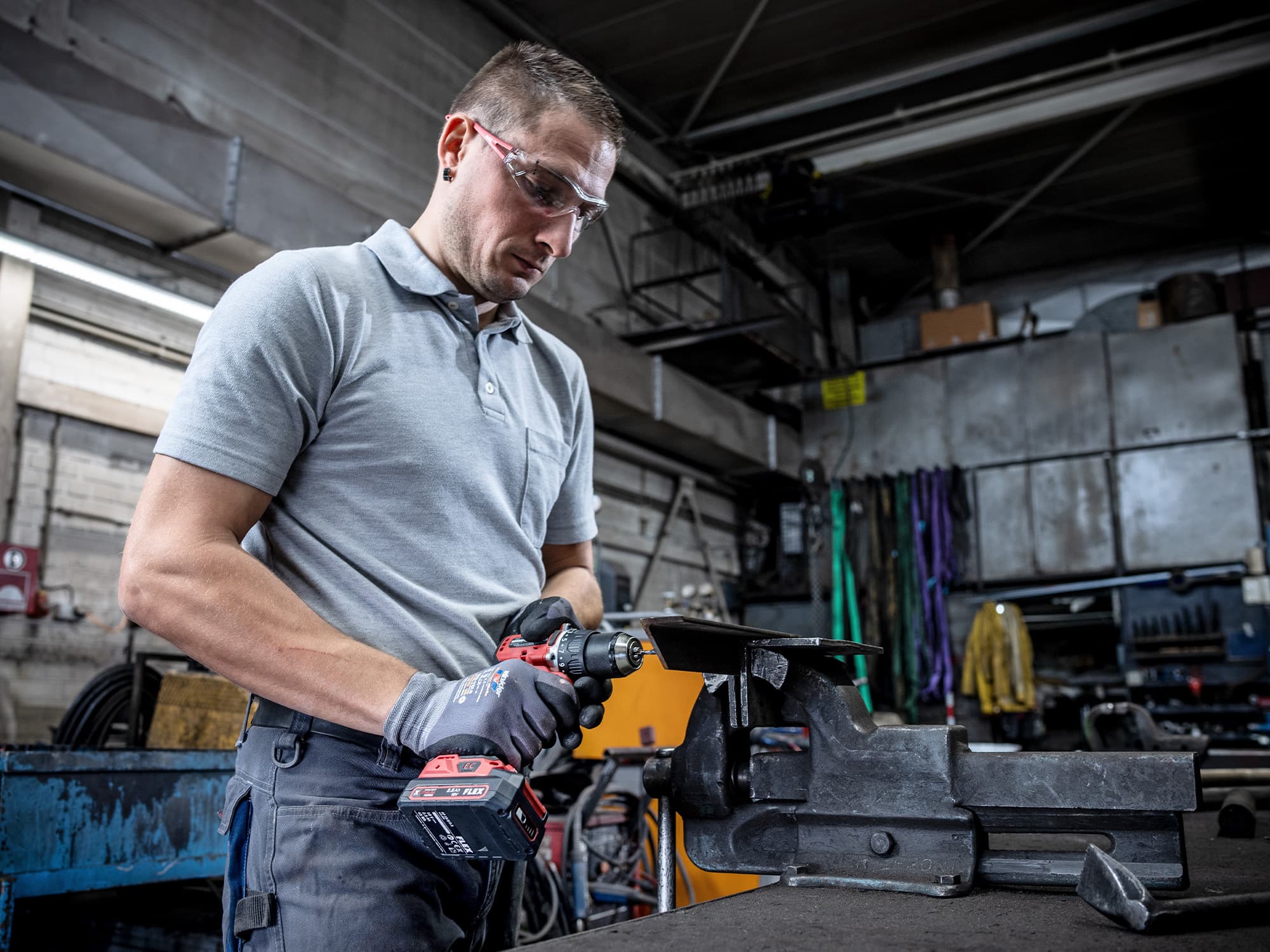 Ein Handwerker bohrt mit einem FLEX Akku-Bohrschrauber in Metall.