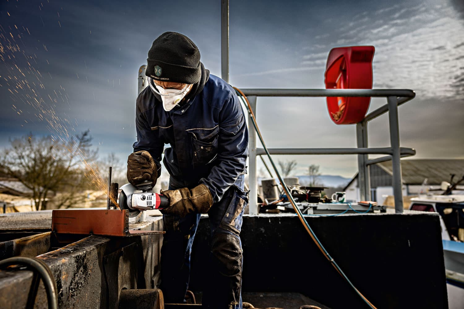 Craftsman uses a FLEX LBP 125-15 18 angle grinder to machine a metal component outdoors