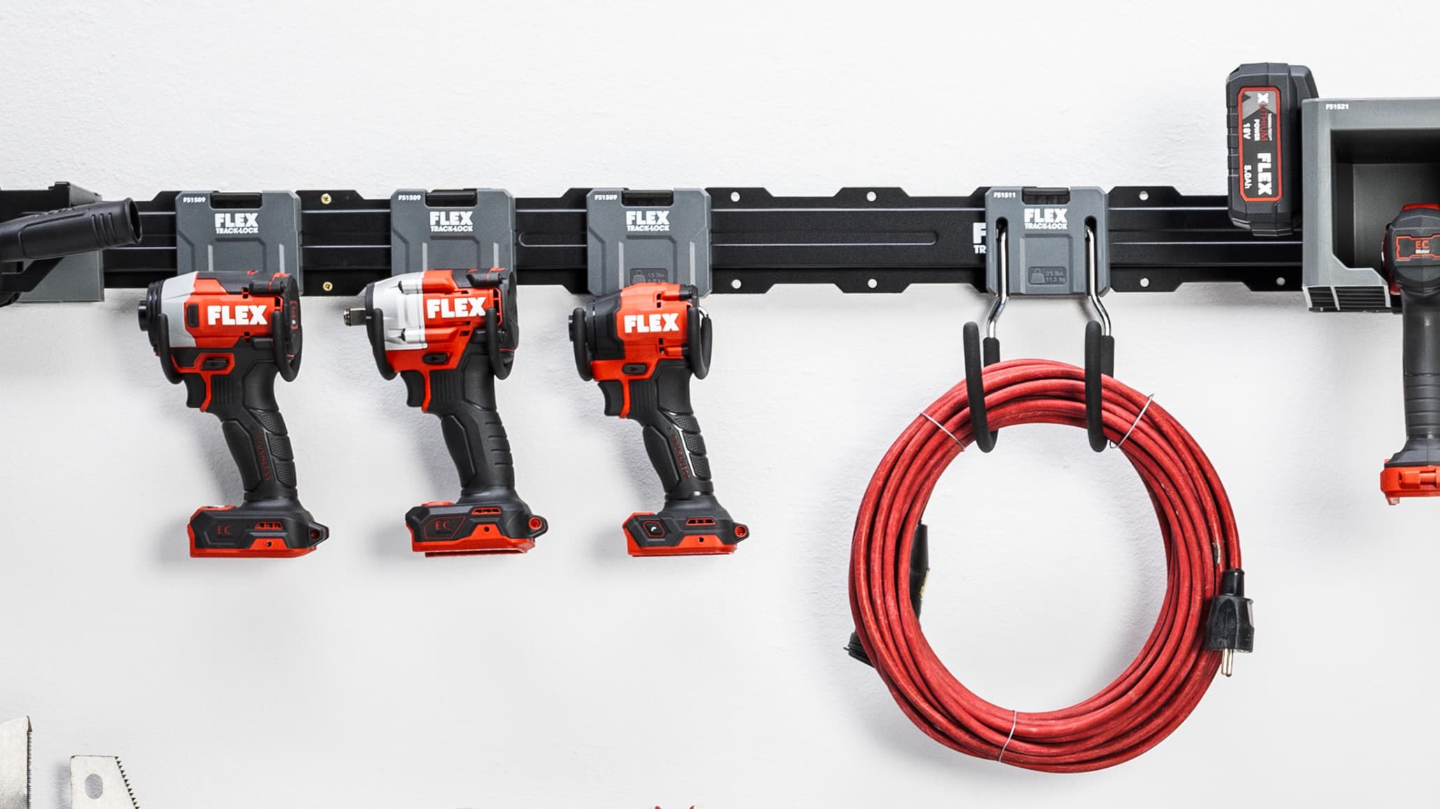 Power tools and extension leads hung on hooks of the FLEX TRACK LOCK system on a wall