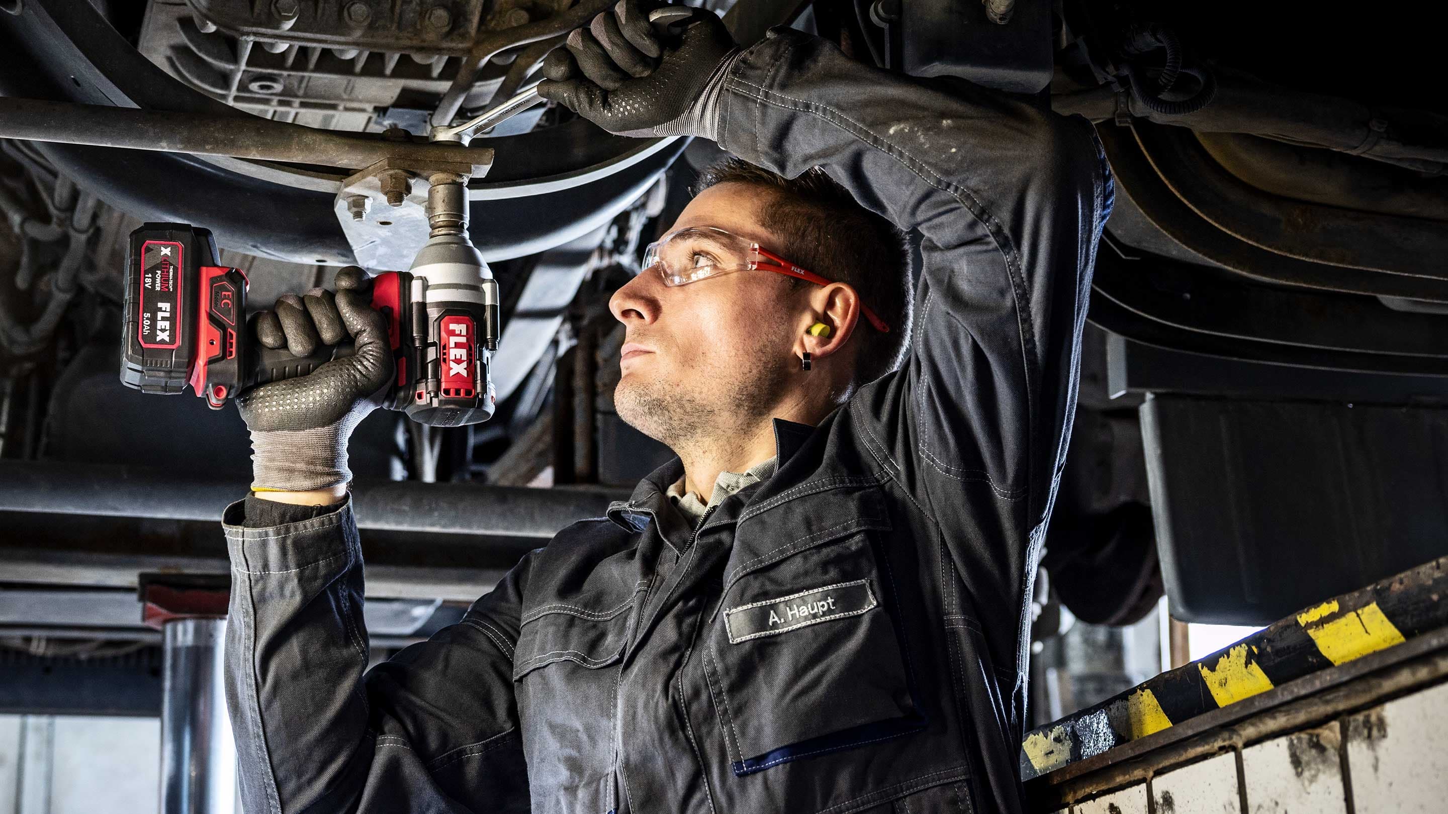 Atelier automobile Desserrer une vis sur le bas de caisse d'un véhicule avec une clé à chocs FLEX